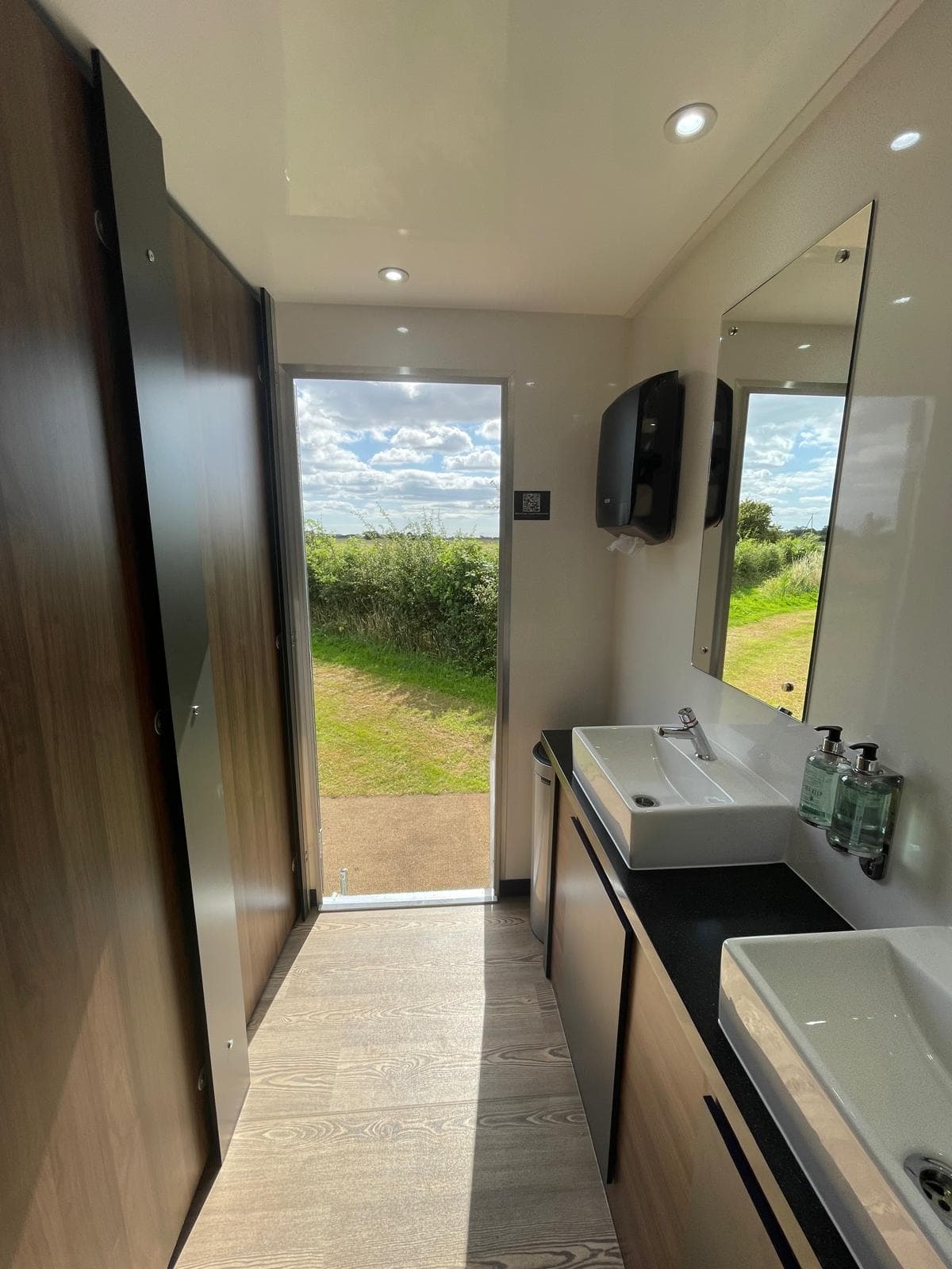 Trailer interior with walnut cabinetry and countryside view